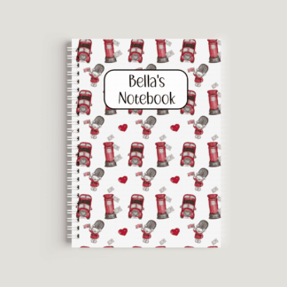 A spiral-bound A5 notebook featuring a repeating pattern of red London buses, red postboxes, and soldiers in uniform. A white label in the center reads "Bella's Notebook" in a whimsical black font.