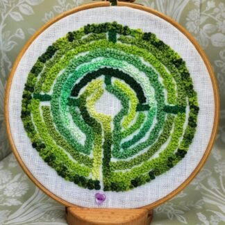 An Embroidery based on a Labyrinth sewn using different shades of green on a 7" embroidery hoop.