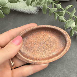 Copper ring trinket dish with leather effect pattern, held in hand to show scale