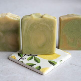 Green and yellow soap bars sitting on a citrus lemon tile