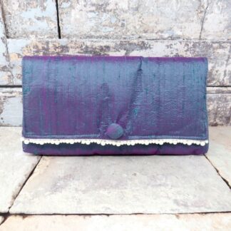 A simple green silk clutch with a pearl trim.