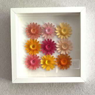 Quilled wall art picture in a white frame - nine die cut daisies with fringed flower quilled centres.