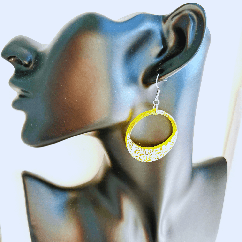 Bold yellow hoop earrings with floral lace detailing on hypoallergenic surgical steel earring hooks