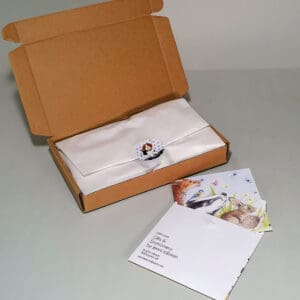 A gift order wrapped in standard tissue paper and a paper character sticker seal. Placed in either a box or padded envelope. With the upgrade personalised gift card in a handmade keepsake printed envelope.