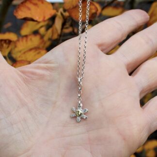 Silver flower pendant with brass centre