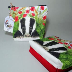 Make up bag with the badger and poppies print on the face and red cotton reverse. Chunky zipper with a daisy charm zip pull.