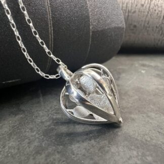 Sterling silver paw print pendant encased in hearts on a chain
