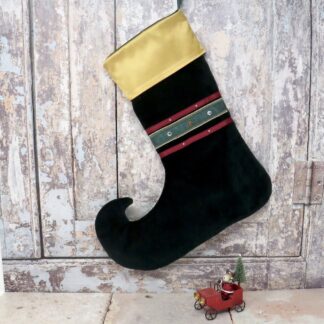 A green velvet christmas stocking with a gold satin cuff.
