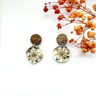 Asymmetric clear earrings with rainbow glitter flakes and cow parsley flowers hung on round dark brown stud toppers. Earrings stud pin and back are hypoallergic surgical steel.