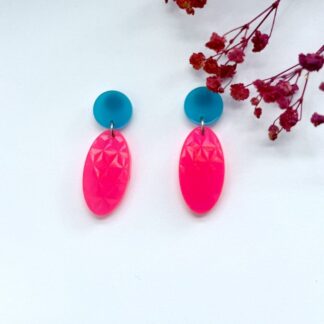 Neon pink earrings with a holographic rainbow texture and a blue stud top.