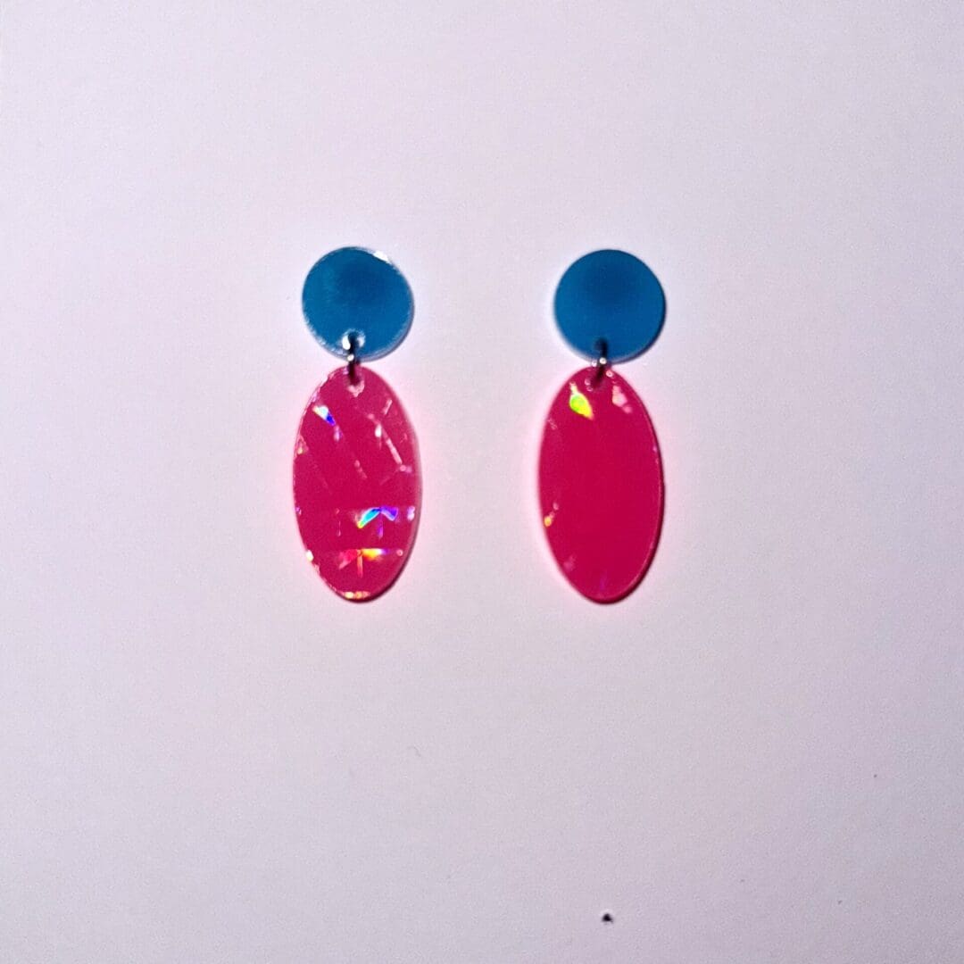 Sunshine lit pink neon earrings with round blue stud top, showing the rainbow holographic texture finish.