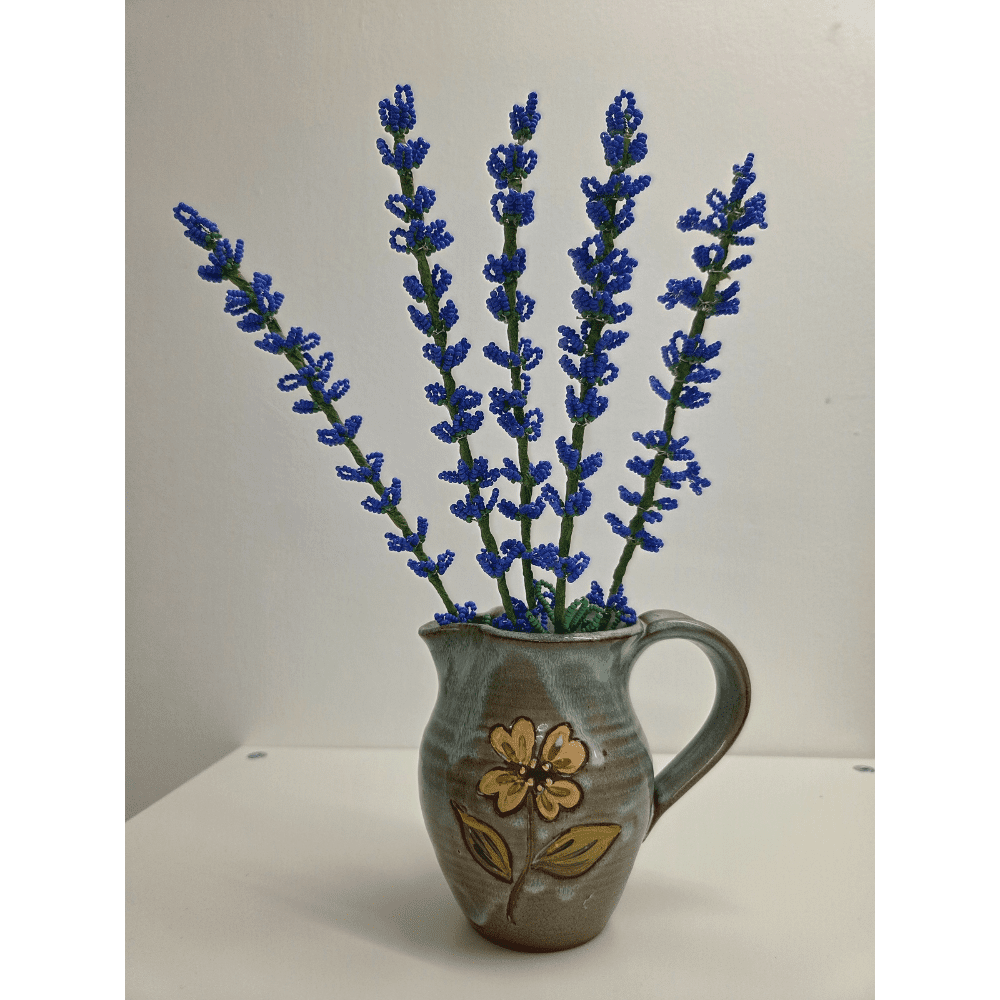 Pictured is 5 stems of french beaded lavender in a blue/green jug with a flower on the front