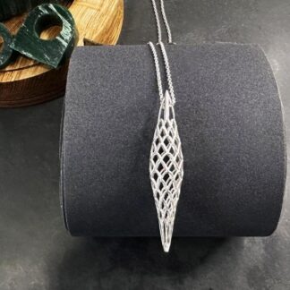 Art deco inspired Sterling silver cage pendant sitting on emery paper roll