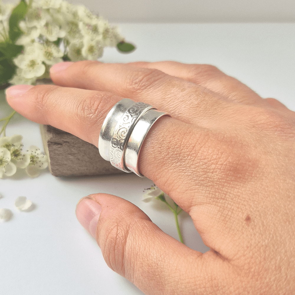 Chunky sterling silver spinner ring being worn on a model's index finger.