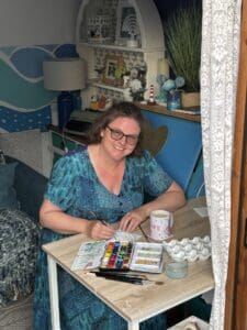 Image is of claire sheehan working in her garden studio which she calls The Snug