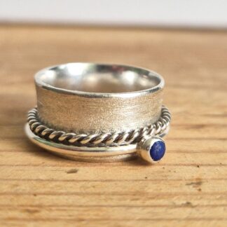 Cover photo shows sterling silver spinner ring with lapis lazuli on a wooden background.