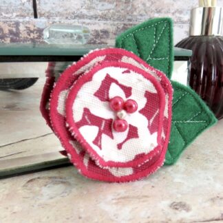 A pretty floral brooch made using fabric and felt.