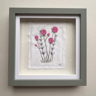 Delicate embroidery of pink flowers in a grey box frame