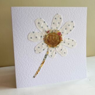 Standing greetings card with an appliqued spotty daisy on front