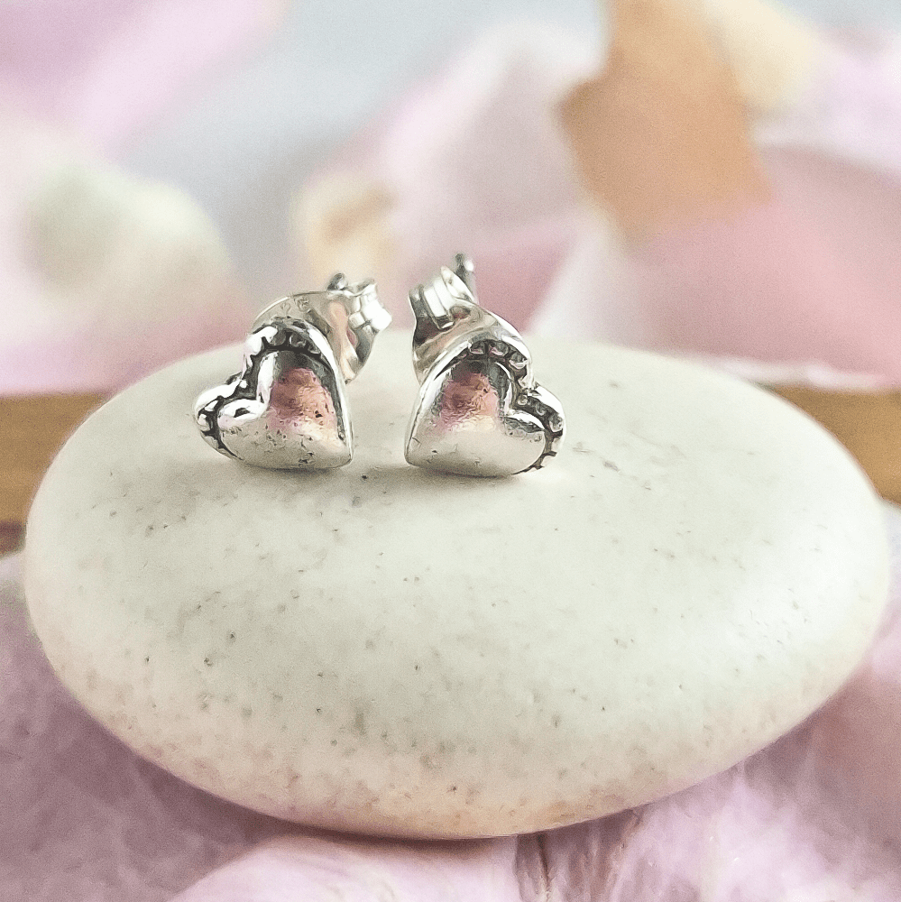 Style D features plain heart-shaped studs with little decorative dots above them.