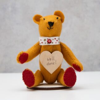 Little tan felt bear with wooden heart with the words well done inscribed on it