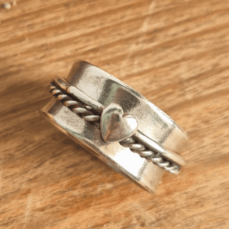 Overhead shot of sterling silver spinner ring on wooden background.