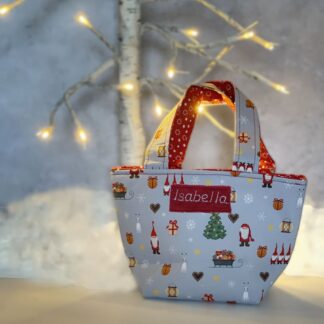 Child's personalised toy tote bag in Christmas scan print fabric in front of lit white tree.