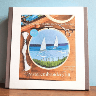Coastal-inspired embroidery kit for beginners with 6 inch hoop and design of sailing boats transferred onto fabric.