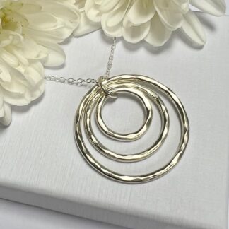 Handmade sterling silver necklace comprising three descending circles with a hammered finish