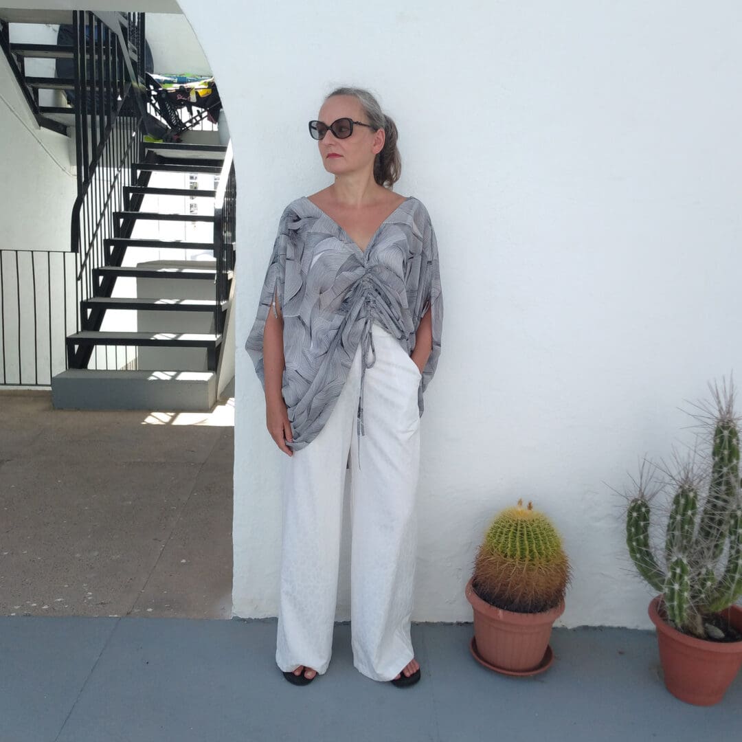 woman wearing short tunic top and white wide leg trousers