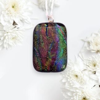 Colorful iridescent dichroic glass pendant with a rainbow sheen, suspended from a delicate silver chain.