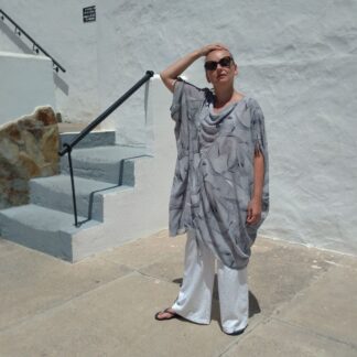 woman wearing oversized kaftan tunic with cowl neck and white trousers