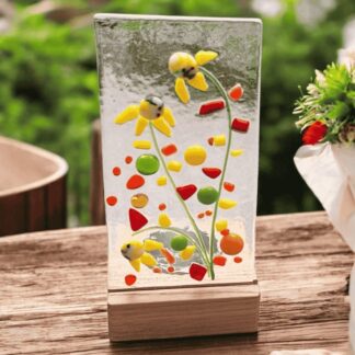 Handmade fused glass candle holder with yellow flower design, raised textured glass, and wooden stand with recess for a tealight candle.