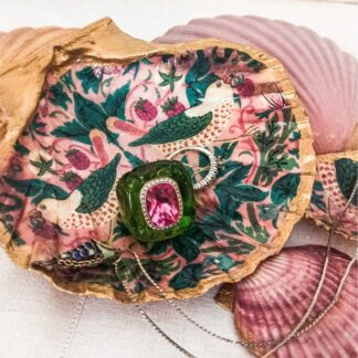 William Morris Strawberry Thief decoupaged scallop shell dish in green and pink with gold painted edging and a pink painted reverse side rests on painted scallop shells. Jewllery is placed within the handcrafted shell dish.