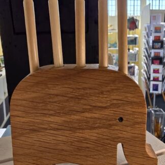 Handmade solid oak pencil holder shaped like an elephant, holding five chunky coloured pencils upright along its back.