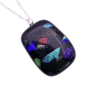 Glass pendant necklace featuring a glossy black surface with vibrant, iridescent multicolored dichroic shapes. Silver chain, modern and elegant design.