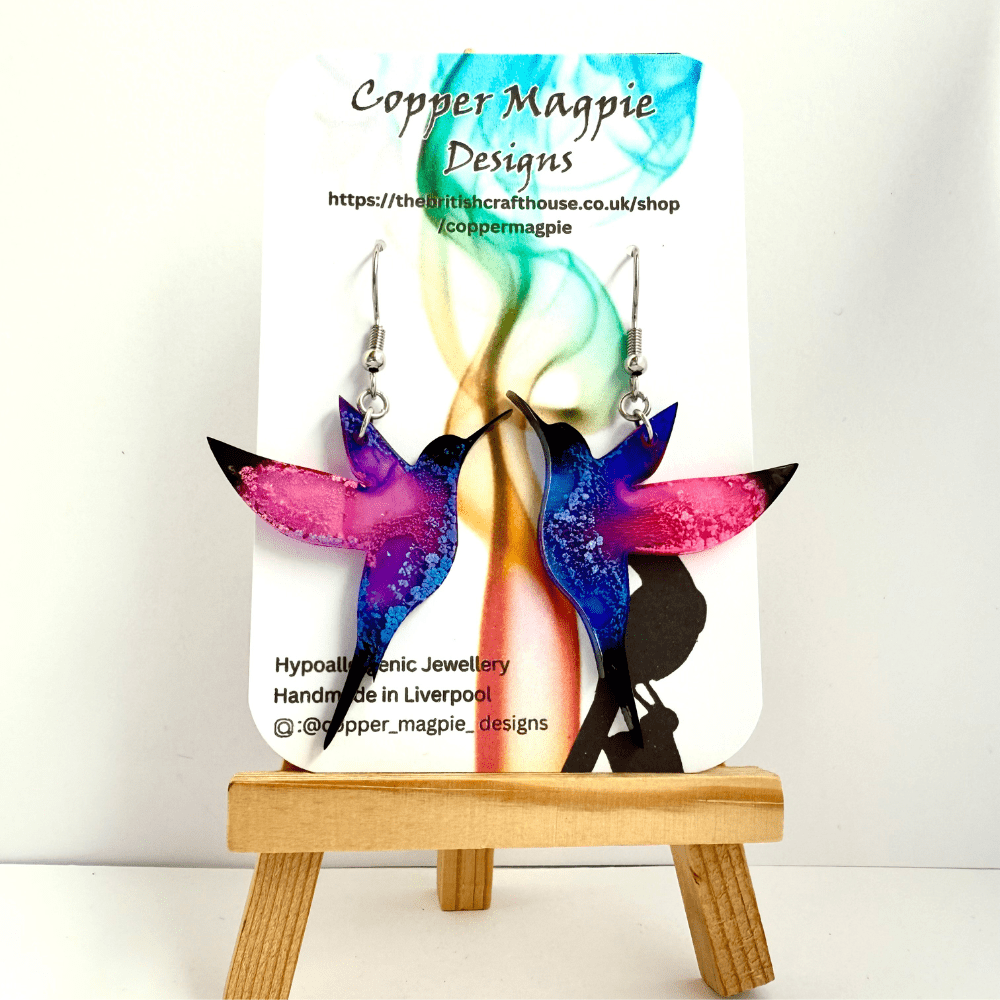 Artistic hummingbird earrings showing a vivid mix of pink, purple and blue shades