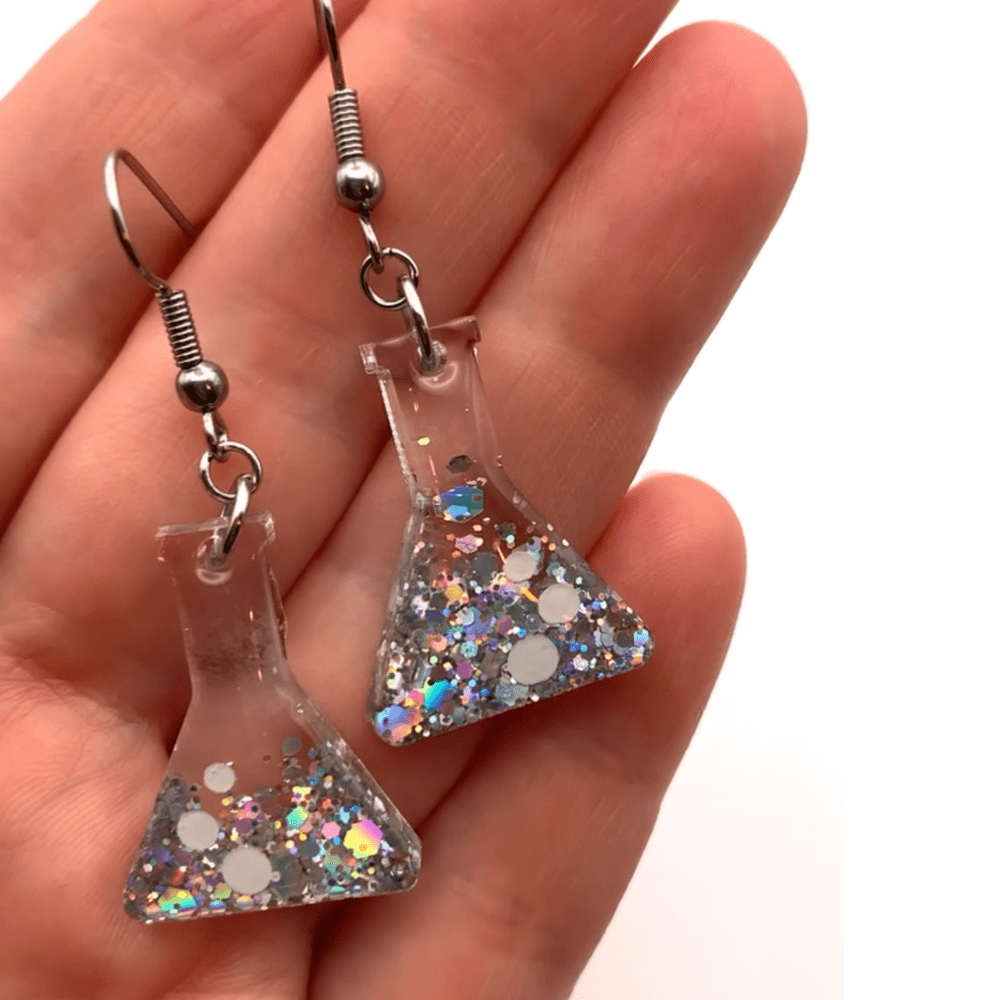 Close-up of silver glitter conical flask earrings for science lovers