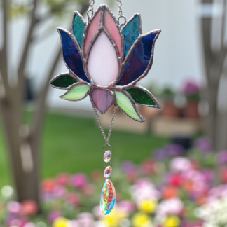 Handmade stained glass lotus flower suncatcher with pink, blue and green petals, finished with a crystal drop that casts rainbows, unique home décor and gift idea.