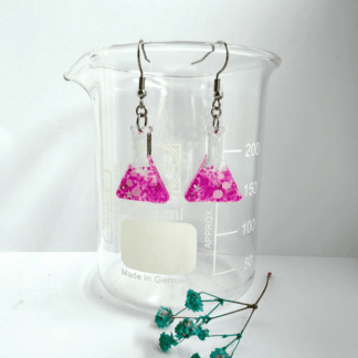 Conical flask shaped earrings with white bubble detail, half filled with candy pink glitter with stars hang from surgical steel ear hooks from a lab beaker.