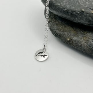 laser engraved trio of jumping dolphins on a sterling silver pendant