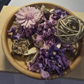 Hand-turned alder wooden potpourri bowl filled with purple dried petals and botanicals, showing the smooth honey-toned grain of the wood.