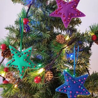 Beaded felt star trio in jewel brights by lyndawilcansew hung on a green tree with lights
