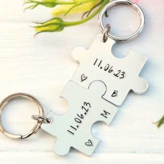 a set of 2 interlocking puzzle shaped keyrings featuring personalised anniversary dates and initials
