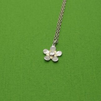 Silver flower pendant necklace with brass star centre