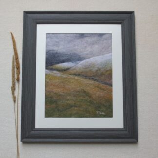 Stormy grey skies over snow topped moorland hills.