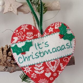 It's Christmaaas! Christmas tree hanging heart fabric decoration in red and white Scandi Xmas fabric with holly and berries motif hanging on a rustic winter foliage branch