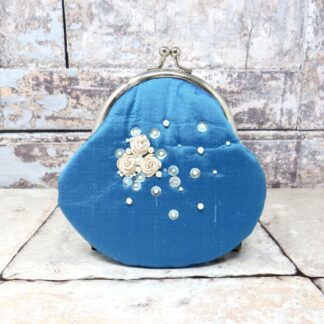 A large beaded blue silk purse with a kisslock clasp.