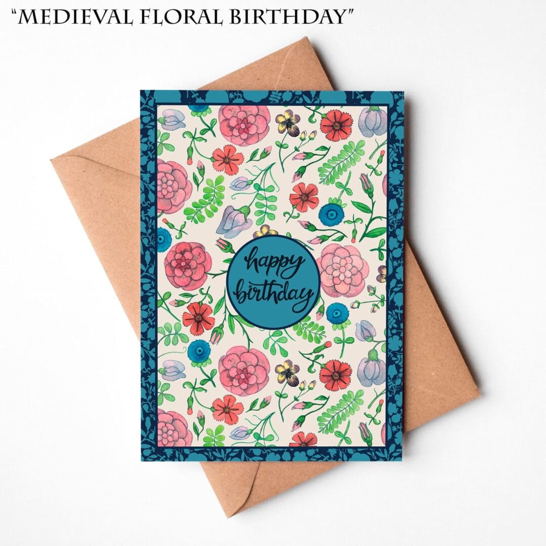 A hand-illustrated birthday card featuring a Medieval-inspired floral border in green and pink tones with the words “Happy Birthday,” resting on a natural brown Kraft envelope.
