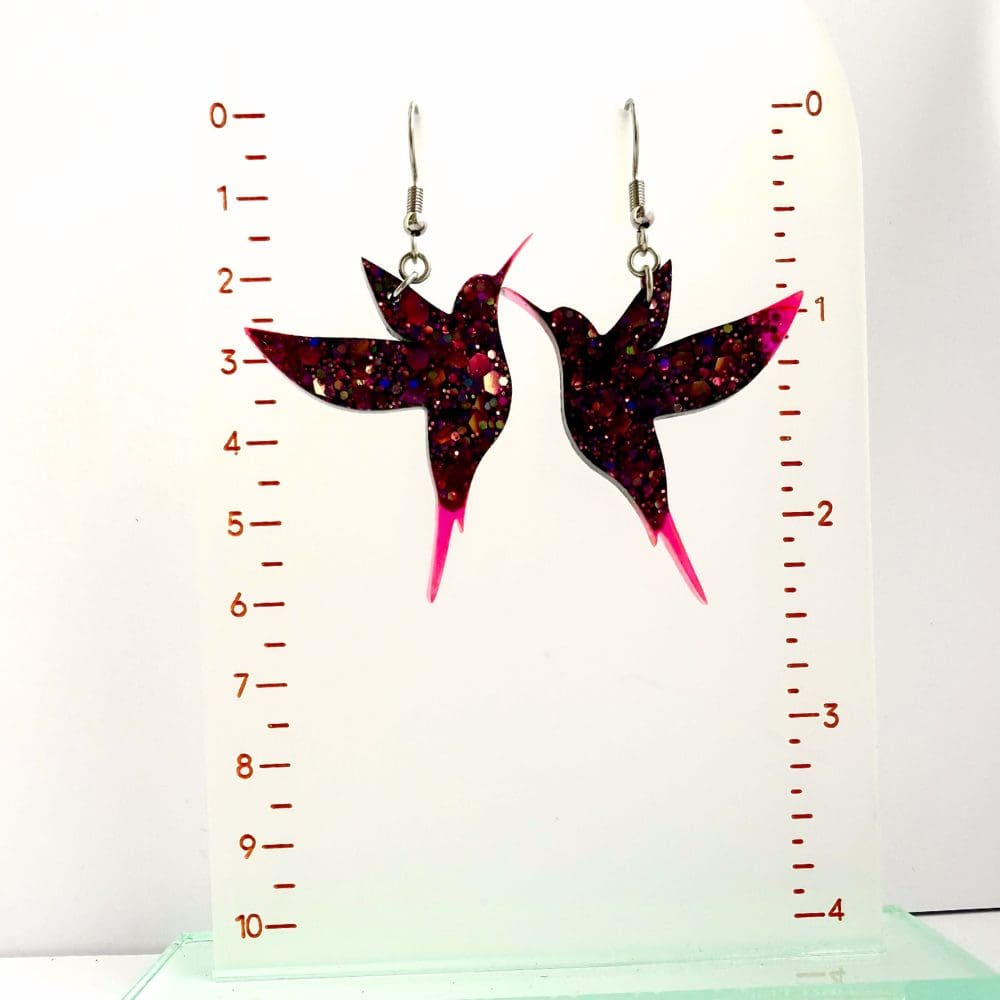 Earrings beside ruler to show dimensions and scale